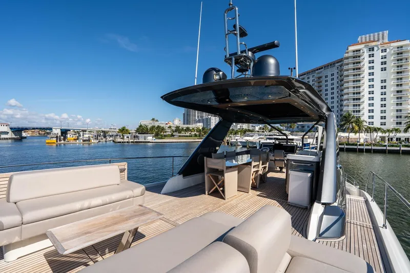 Slide: The Image of Luxurious 2022 Prestige X70 yacht deck with seating, dining area, and waterfront city view. - 20