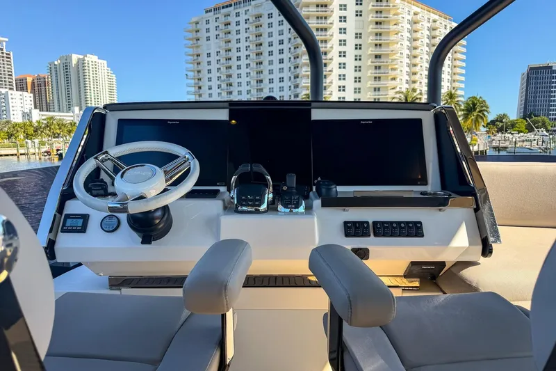 Slide: The Image of Prestige X70 2022 yacht helm with modern controls and cityscape background. - 26
