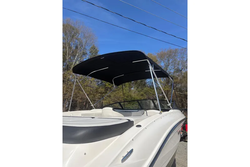 Slide: The Image of 2023 Sea Ray SPX 210 Outboard boat with black canopy, parked outdoors. - 10