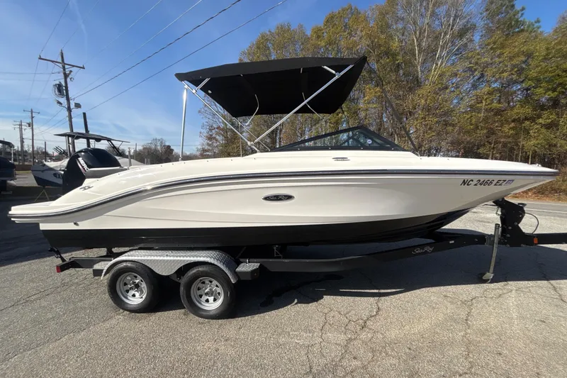Slide: The Image of 2023 Sea Ray SPX 210 Outboard boat on trailer, parked outdoors. - 2