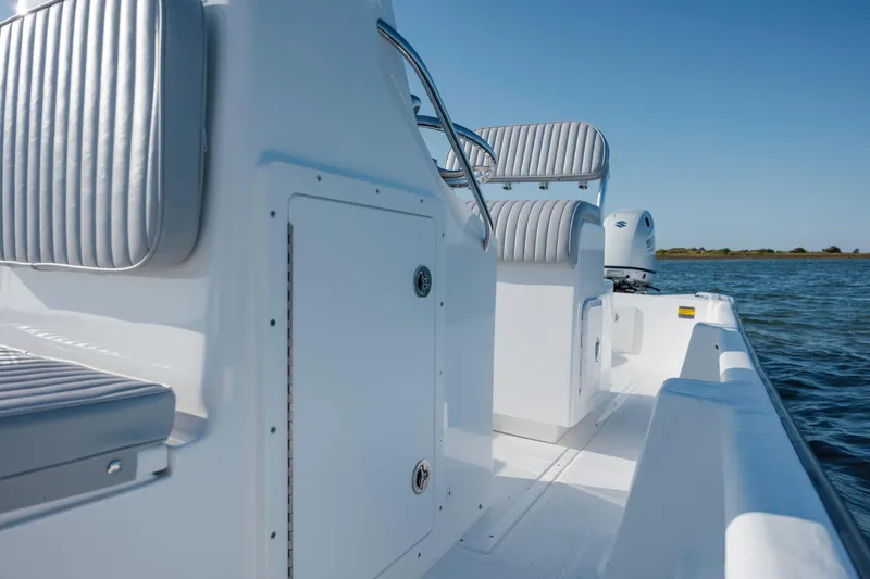 Slide: The Image of 2025 Panga Eduardono boat interior with sleek seating, on calm water under clear blue sky. - 3