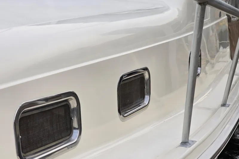 Slide: The Image of Side view of 2001 Mainship 30 Pilot Rum Runner boat with portholes and railing. - 12