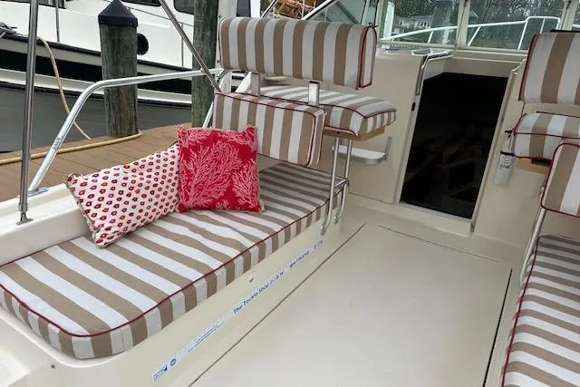 Slide: The Image of 2001 Mainship 30 Pilot Rum Runner boat interior with striped seating and decorative pillows. - 14