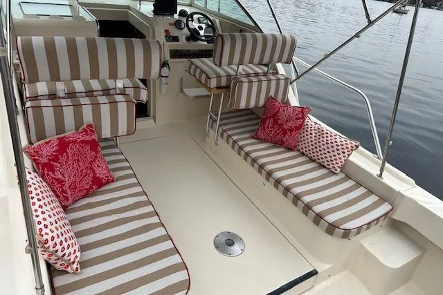 Slide: The Image of 2001 Mainship 30 Pilot Rum Runner boat interior with striped seating and red cushions. - 15
