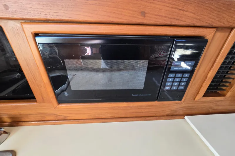Slide: The Image of Built-in microwave in 2001 Mainship 30 Pilot Rum Runner boat kitchen. - 23