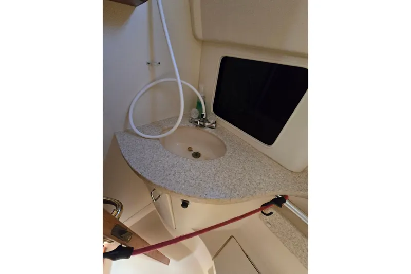 Slide: The Image of 2001 Mainship 30 Pilot Rum Runner boat interior sink area with countertop and faucet. - 26