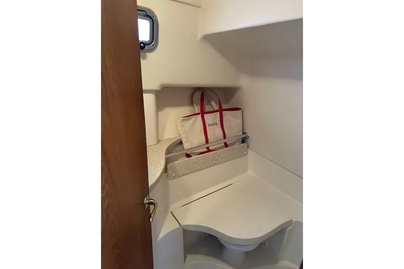 Slide: The Image of 2001 Mainship 30 Pilot Rum Runner boat interior with compact bathroom and storage. - 27
