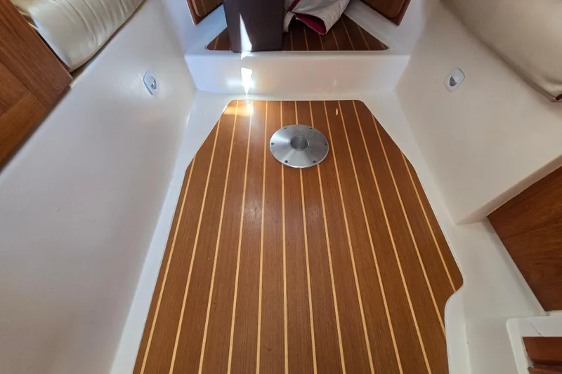 Slide: The Image of 2001 Mainship 30 Pilot Rum Runner interior with wood flooring and seating area. - 30