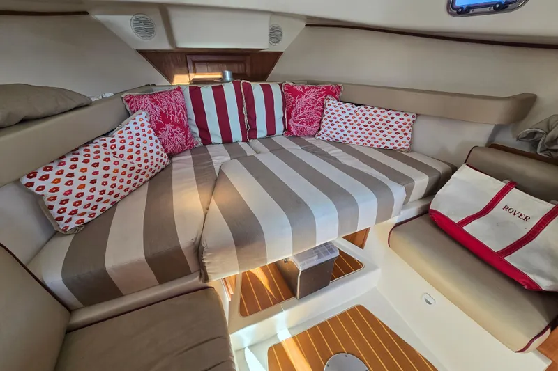 Slide: The Image of Cozy cabin interior of 2001 Mainship 30 Pilot Rum Runner with striped cushions and decorative pillows. - 31