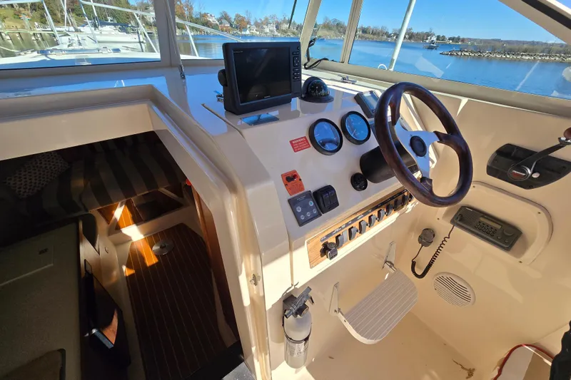 Slide: The Image of 2001 Mainship 30 PILOT helm with steering wheel, gauges, and navigation equipment. - 4