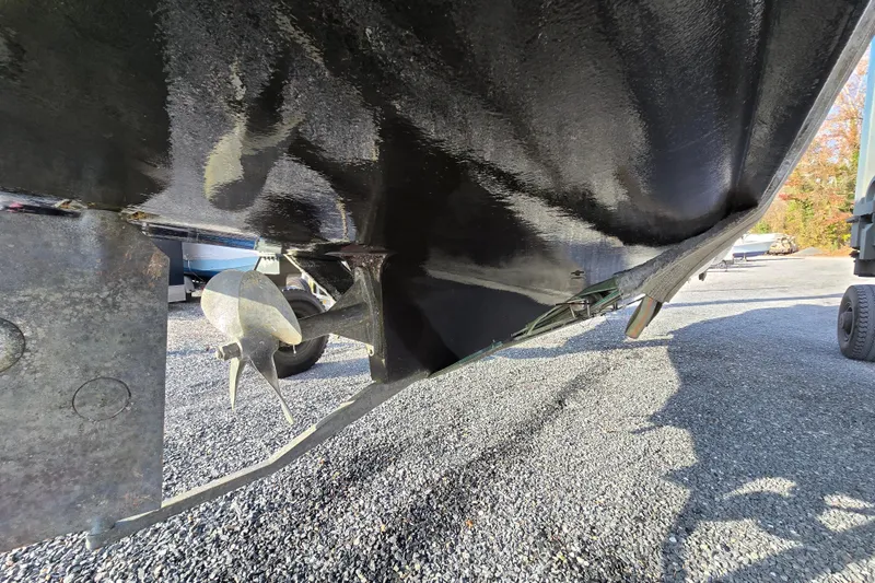 Slide: The Image of 2001 Mainship 30 Pilot Rum Runner boat propeller and hull on gravel surface. - 43