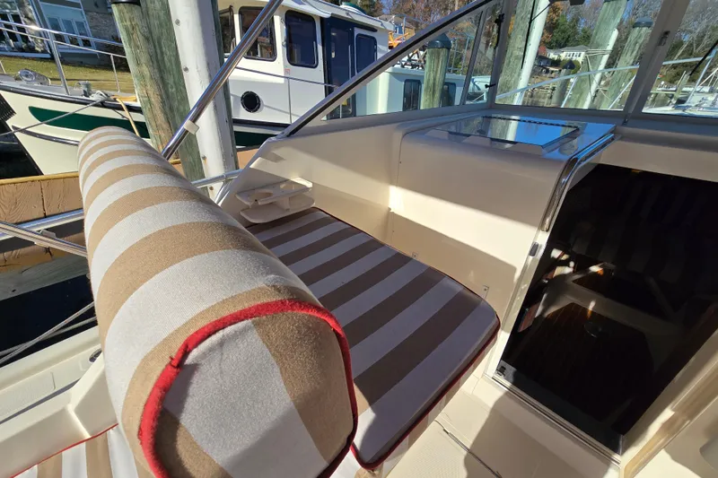 Slide: The Image of 2001 Mainship 30 PILOT boat interior with striped seating and helm area. - 7