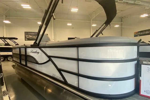 Slide: The Image of 2026 Bentley Pontoons Legacy 223 Navigator in showroom, sleek design with black accents. - 25