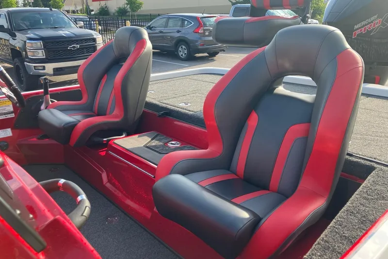Slide: The Image of Red and black seats in a 2026 Nitro Z19 XL boat, parked outdoors. - 5