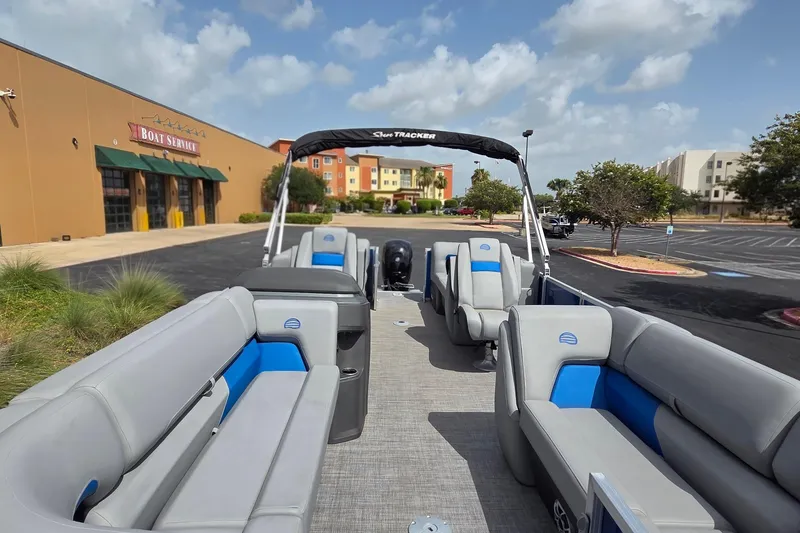Slide: The Image of 2026 Sun Tracker Party Barge 22 DLX pontoon boat parked near boat service center. - 2