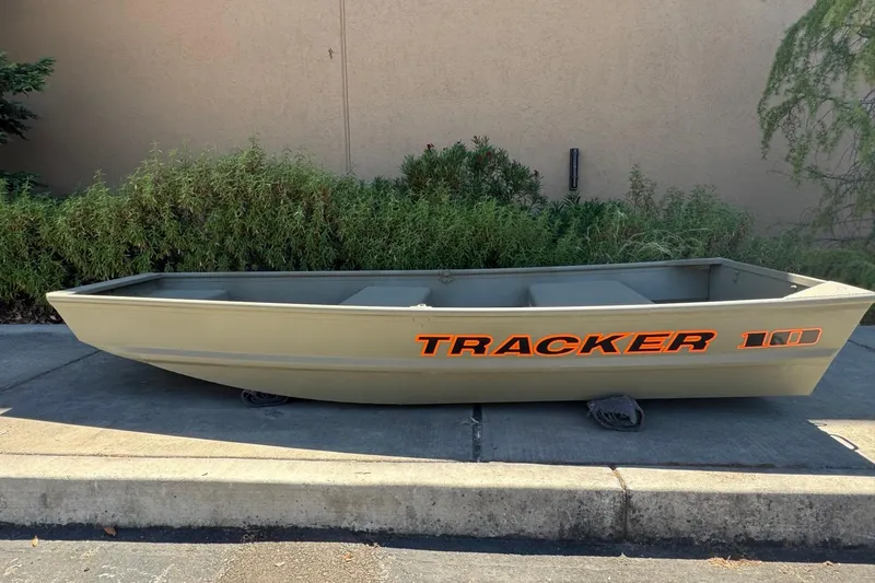 The Image of 2026 Tracker Grizzly 10 Jon boat on pavement, green exterior, orange branding. - 0