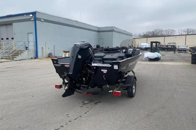 Slide: The Image of 2026 Tracker Pro Guide V-16 SC boat on trailer in industrial area. - 49