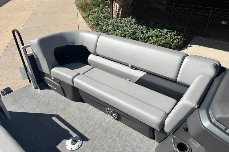 Slide: The Image of 2026 Sun Tracker SportFish 22 DLX pontoon boat with gray seating and deck. - 14