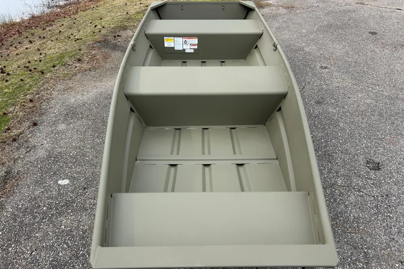Slide: The Image of 2026 Tracker Grizzly 14 Jon boat on a paved surface near grassy area. - 3