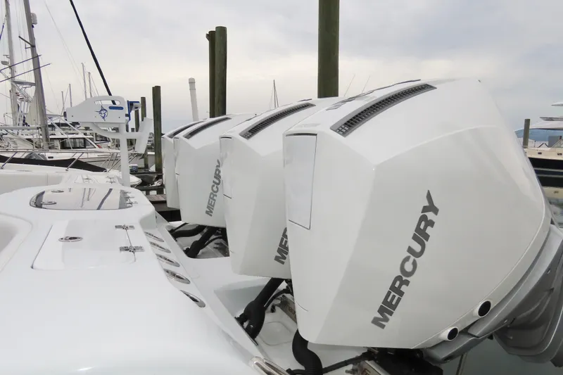 Slide: The Image of Triple Mercury outboard engines on a 2024 Freeman 38 boat at a marina. - 3
