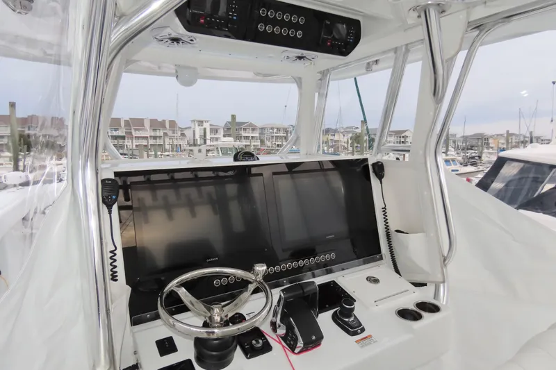 Slide: The Image of 2024 Freeman 38 boat helm with advanced navigation system and steering wheel in marina setting. - 5