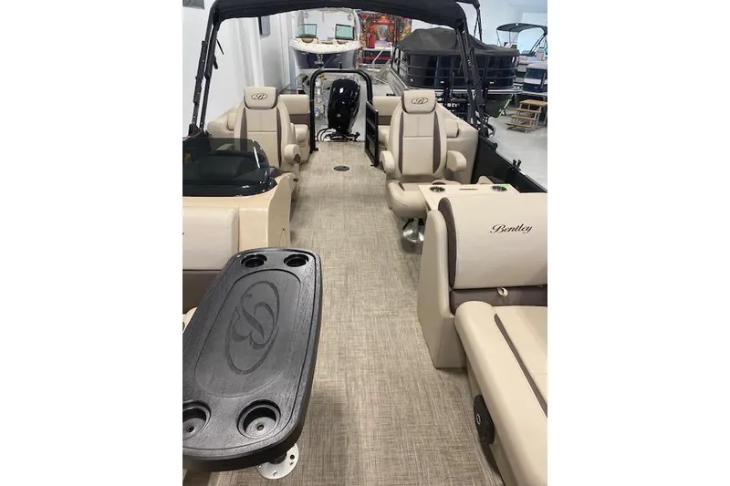 Slide: The Image of 2026 Bentley Pontoons Legacy 223 Navigator interior with beige seating and black table. - 22