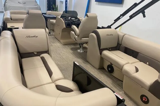 Slide: The Image of 2026 Bentley Pontoons Legacy 223 Navigator interior with luxurious beige seating and modern dashboard. - 24