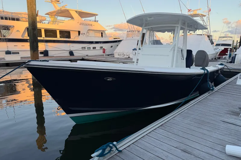 Slide: The Image of 2015 Albury Brothers 27 boat docked at marina, surrounded by yachts. - 2