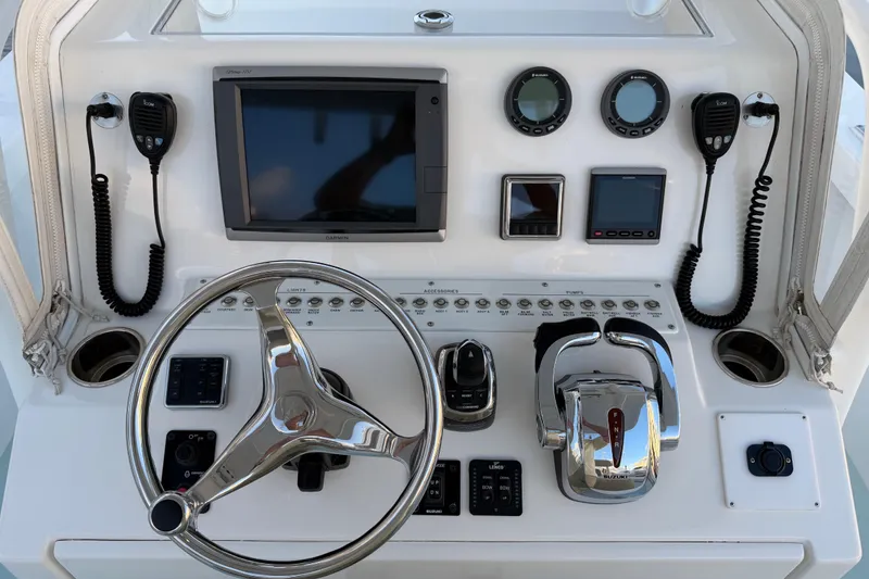 Slide: The Image of Control panel of a 2015 Albury Brothers 27 boat with steering wheel and navigation instruments. - 8