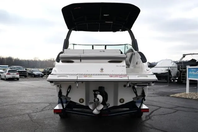Slide: The Image of 2026 Sea Ray SLX 260 boat, rear view, parked on a trailer in a marina. - 14