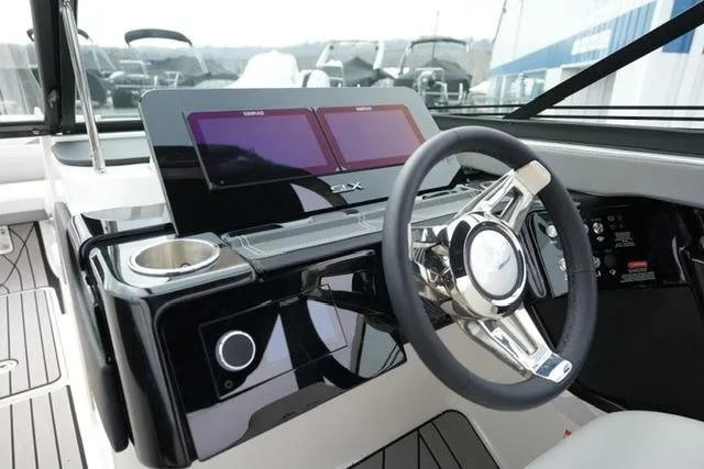 Slide: The Image of 2026 Sea Ray SLX 260 boat dashboard with modern steering wheel and dual screens. - 24