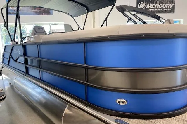 Slide: The Image of 2026 Bentley Pontoons Legacy 223 Swingback in showroom, featuring sleek blue design. - 2