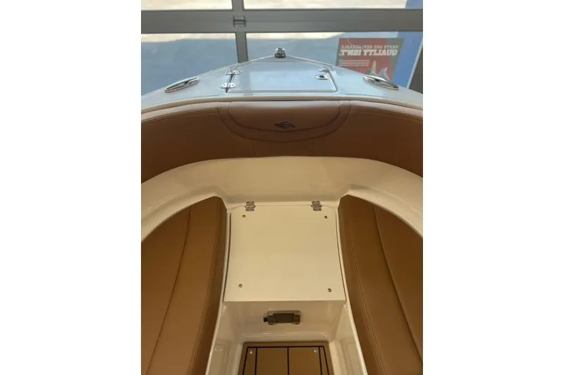 Slide: The Image of 2025 Chaparral 247 SSX boat interior with brown seating and storage compartment. - 13