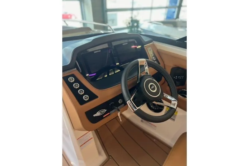 Slide: The Image of 2025 Chaparral 247 SSX boat dashboard with steering wheel and digital displays. - 19