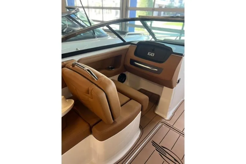 Slide: The Image of 2025 Chaparral 247 SSX boat interior with tan seating and sleek dashboard design. - 25