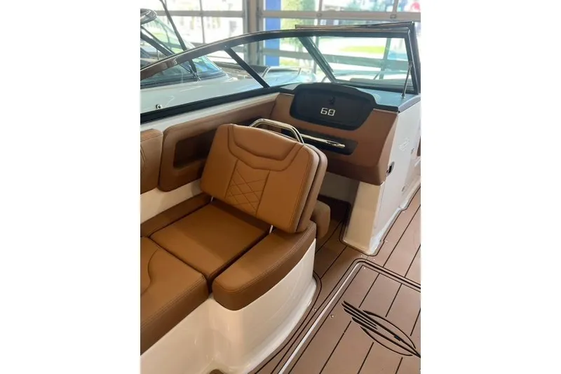 Slide: The Image of 2025 Chaparral 247 SSX boat interior with brown leather seating and modern dashboard. - 26