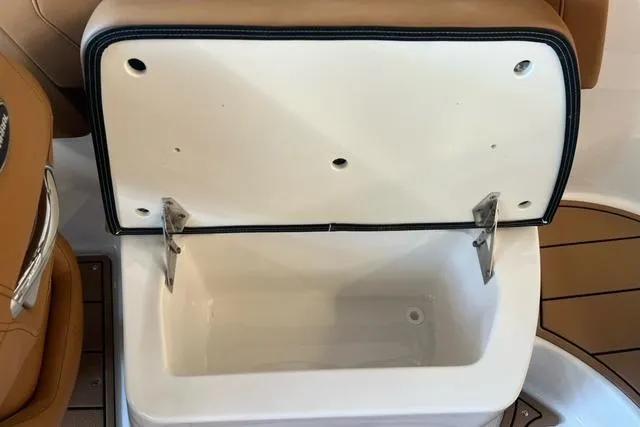 Slide: The Image of Open storage compartment in 2025 Chaparral 247 SSX boat, featuring tan and white interior. - 34