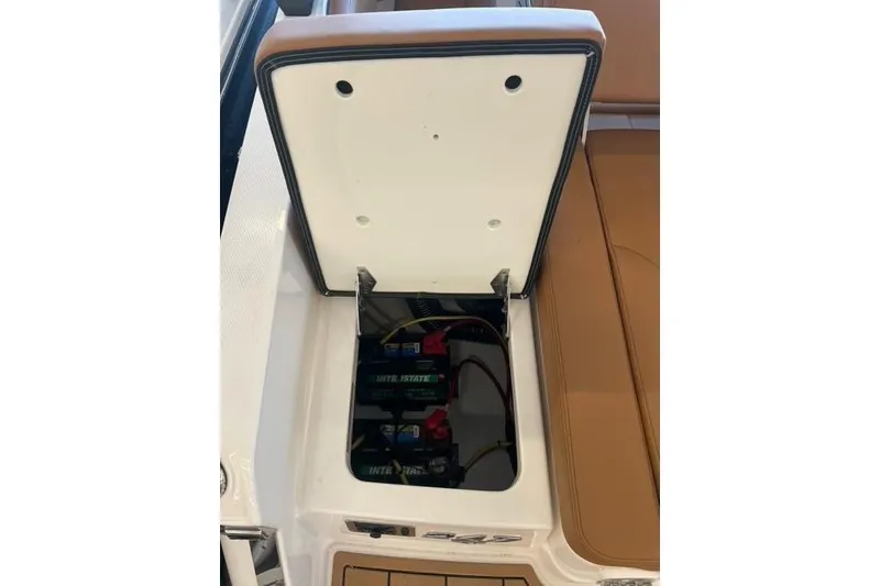 Slide: The Image of Open battery compartment of 2025 Chaparral 247 SSX boat, showcasing interior components. - 37