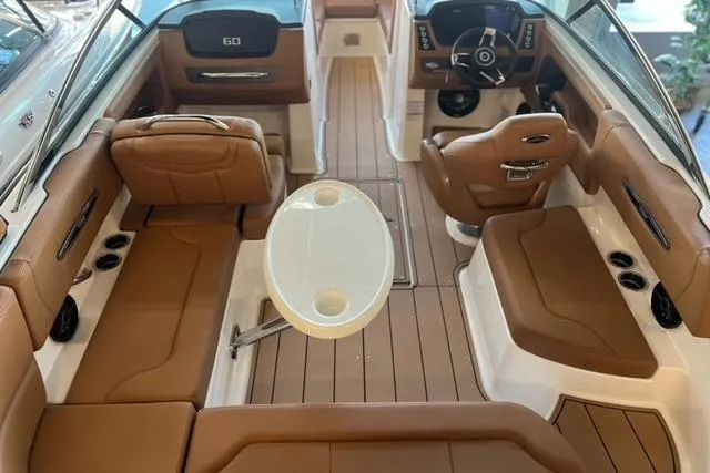Slide: The Image of 2025 Chaparral 247 SSX boat interior with brown seating and white table. - 39