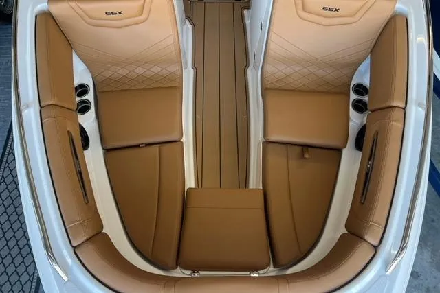 Slide: The Image of 2025 Chaparral 247 SSX boat interior with tan leather seating and cup holders. - 7