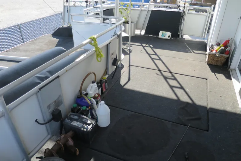 Slide: The Image of 2001 Sumerset Houseboat deck with railing and blue fender, docked at marina. - 10