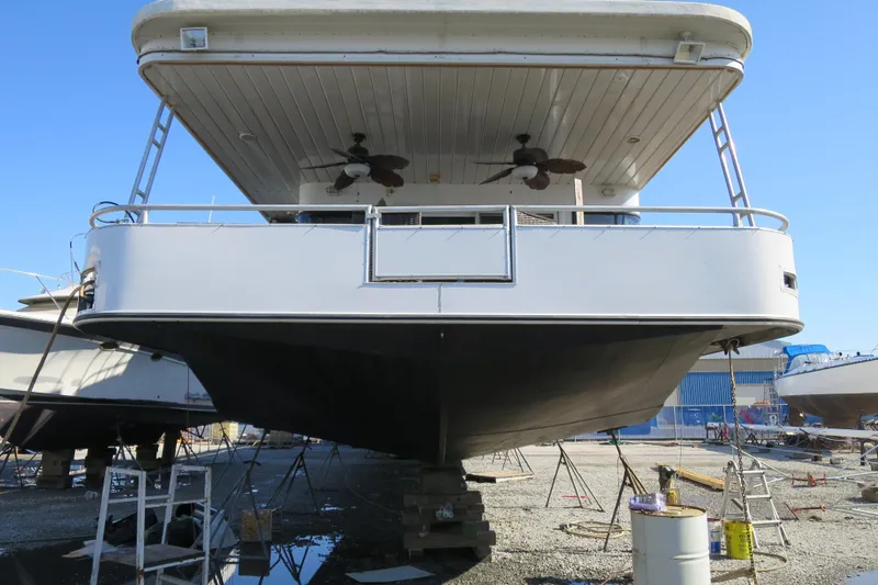Slide: The Image of 2001 Sumerset Houseboat deck with steering wheel and green cover. - 4