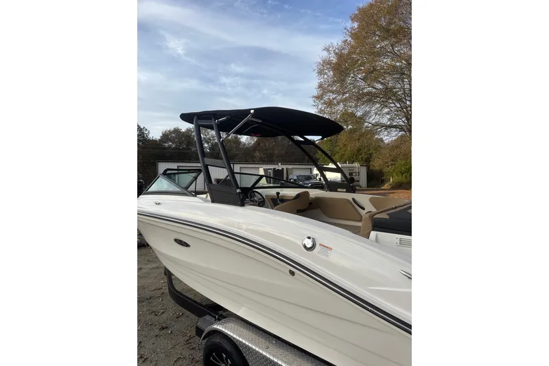 Slide: The Image of 2023 Sea Ray SPX 210 boat on trailer, parked in wooded area. - 11