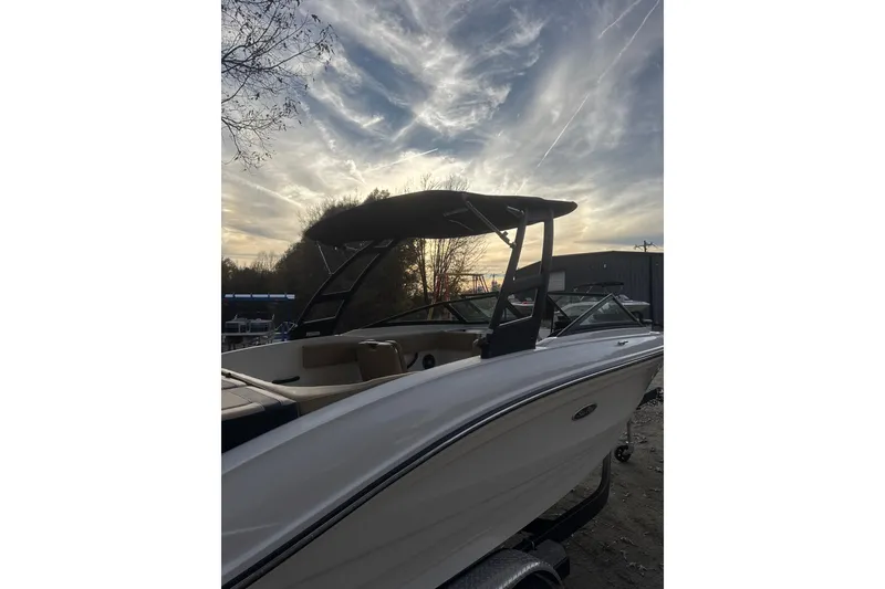 Slide: The Image of 2023 Sea Ray SPX 210 boat with sleek design and black canopy, parked outdoors. - 12
