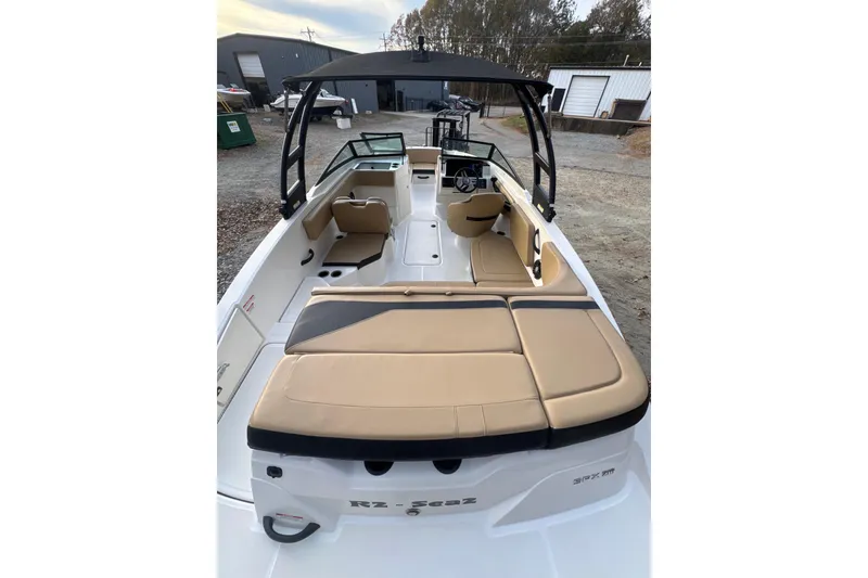 Slide: The Image of 2023 Sea Ray SPX 210 boat, rear view, parked outdoors on a gravel surface. - 17