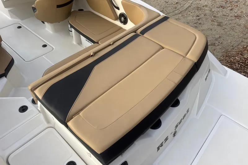 Slide: The Image of 2023 Sea Ray SPX 210 boat with tan seating and black canopy, docked outdoors. - 18