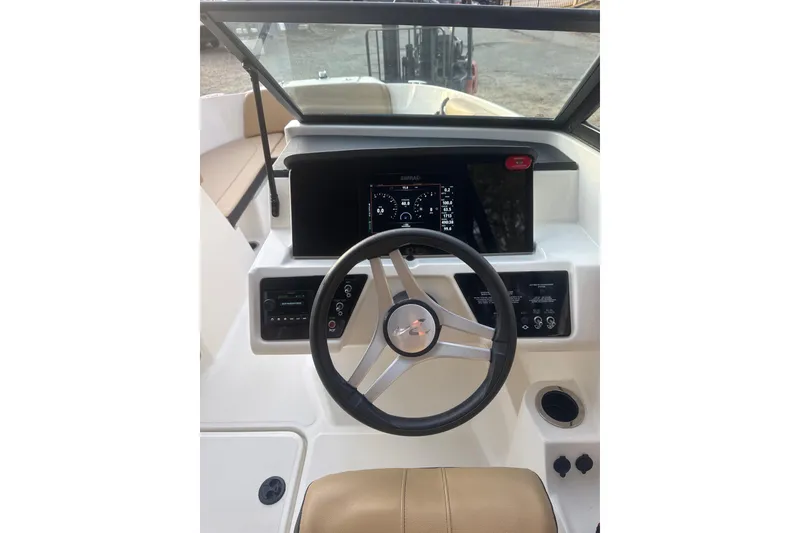 Slide: The Image of 2023 Sea Ray SPX 210 boat interior with tan seating and open windshield. - 20