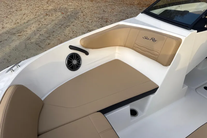 Slide: The Image of 2023 Sea Ray SPX 210 boat interior with tan seating and Sea Ray logo. - 23