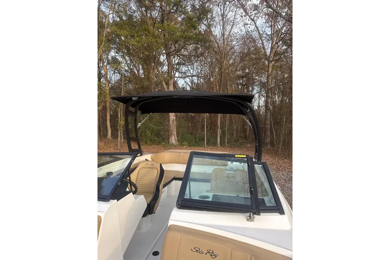 Slide: The Image of 2023 Sea Ray SPX 210 boat cruising on a serene lake near a wooded shoreline. - 6