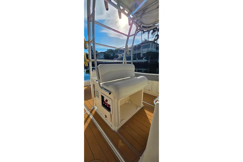 Slide: The Image of 2004 World Cat 330 TE boat interior with helm, docked by palm trees under blue sky. - 10